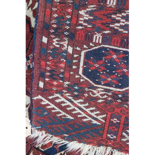 728 - An antique Bokhara carpet of traditional design with forty-eight octagonal guls on a plum ground, 10... 