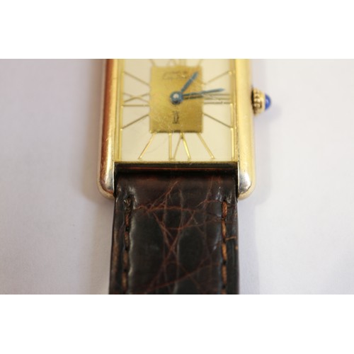 381 - A Cartier Tank Quartz silver gilt cased wristwatch with cream and gilt dial, and Roman numerals, on ... 