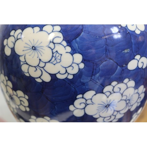 132 - A 19th century Chinese blue and white prunus decorated ginger jar with carved hardwood cover and sta... 