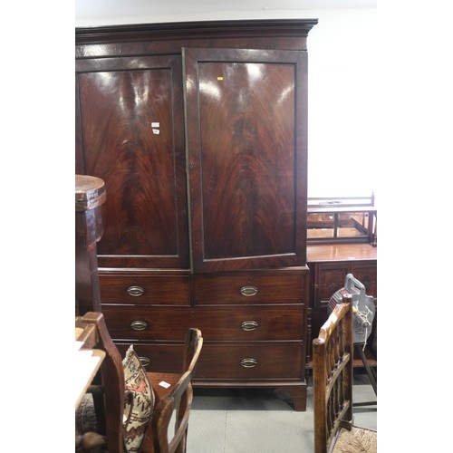 544 - An early 19th century figured mahogany linen press, the upper section fitted trays enclosed two pane... 