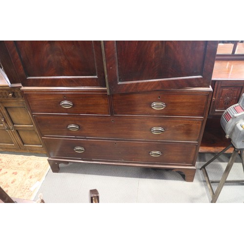 544 - An early 19th century figured mahogany linen press, the upper section fitted trays enclosed two pane... 