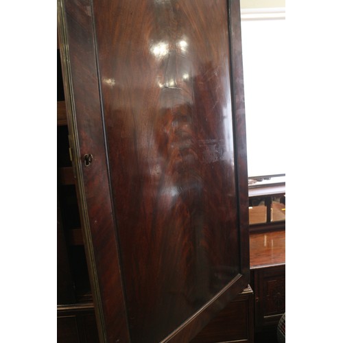 544 - An early 19th century figured mahogany linen press, the upper section fitted trays enclosed two pane... 