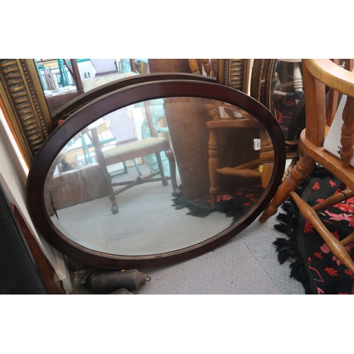 542 - An oak oval framed wall mirror with bevelled plate, 31