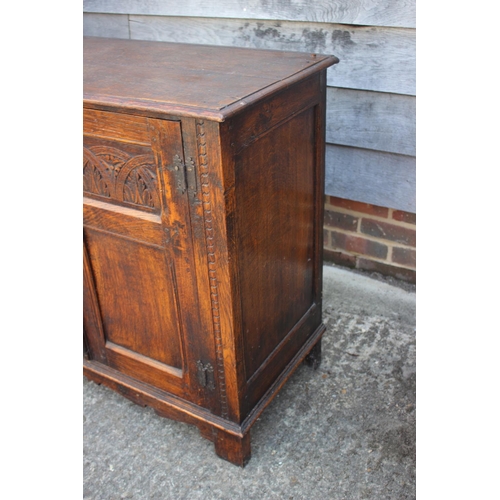 557 - An oak panelled cupboard of 17th century design enclosed two doors, on stile supports, 38