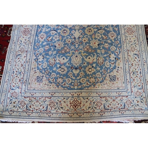 625 - A Kashan wool and part silk pile rug with star medallion and flower design on a blue ground and mult... 