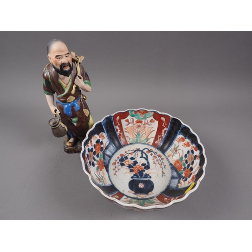 112 - A Japanese Imari bowl with traditional design and a Japanese porcelain figure of a man with stool, 1... 