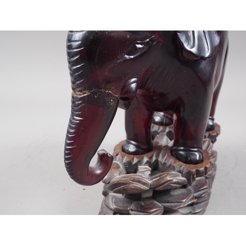 127 - A Chinese lacquer box, a resin model of an elephant, on carved wood stand, a metal model of a deity ... 