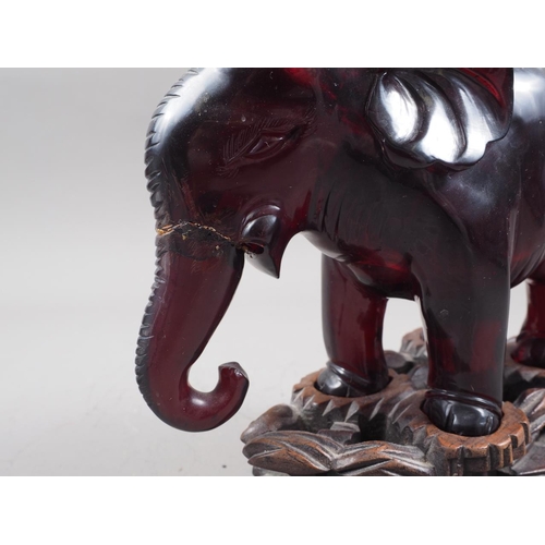 127 - A Chinese lacquer box, a resin model of an elephant, on carved wood stand, a metal model of a deity ... 