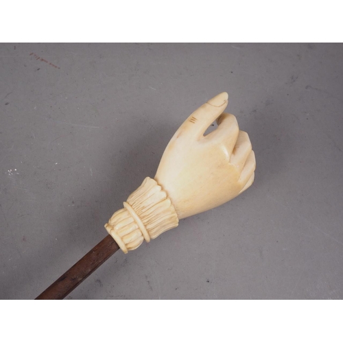 131 - A 19th century carved ivory hand back-scratcher with palm wood stem, 17 1/2