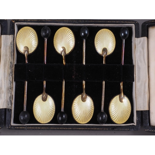 313 - A set of six silver gilt and enamelled coffee spoons with bean handles, in case, and a set of silver... 