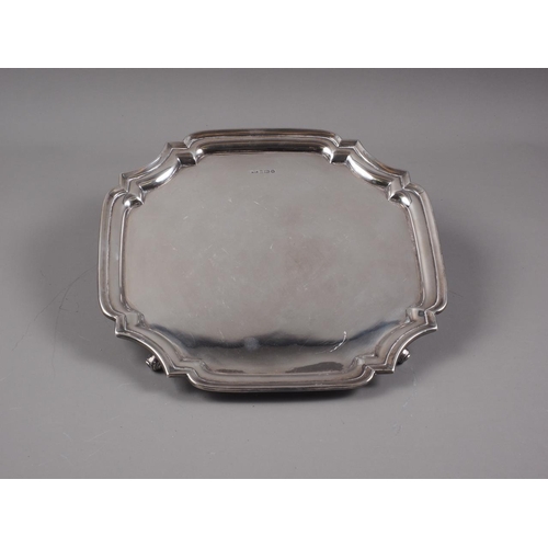 322 - An octagonal silver salver, on four scrolled supports, 20.9oz troy approx