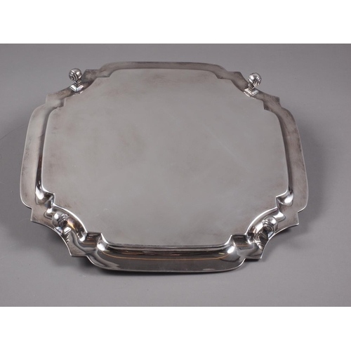 322 - An octagonal silver salver, on four scrolled supports, 20.9oz troy approx