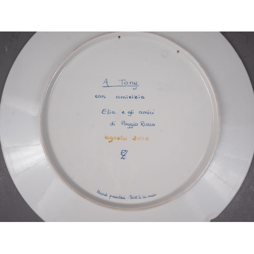 36 - An Italian plate, decorated with a nude woman playing the violin (chip to rim)