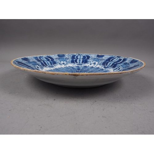 41 - An 18th century Delft shallow bowl with vase of flowers decoration, 12