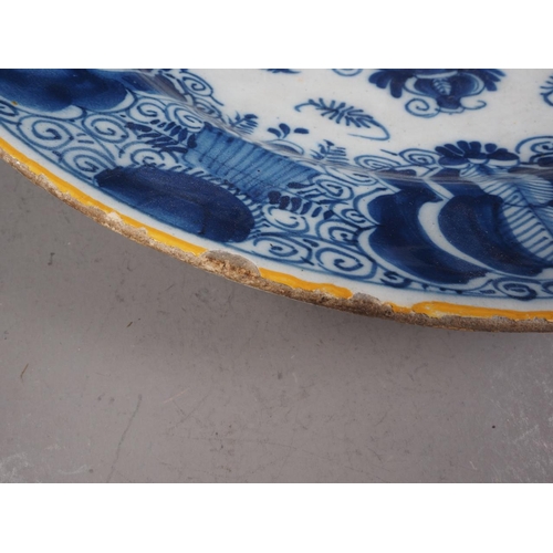 41 - An 18th century Delft shallow bowl with vase of flowers decoration, 12