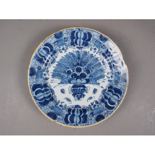 41 - An 18th century Delft shallow bowl with vase of flowers decoration, 12