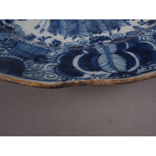 41 - An 18th century Delft shallow bowl with vase of flowers decoration, 12