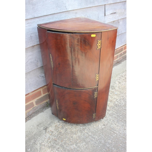 523 - A 19th century mahogany and gilt brass mounted bowfront corner cupboard enclosed two doors, 19