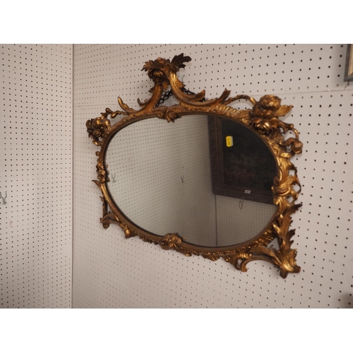 543 - A 19th century carved giltwood framed oval wall mirror with roses on scroll surmounts, plate 14