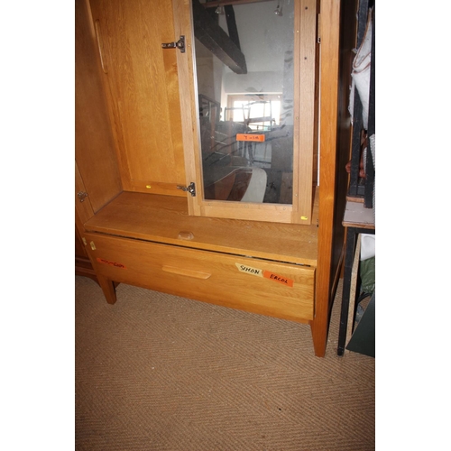 546 - A pair of Ercol light oak wardrobes enclosed panel doors with fitted interior mirror over one long d... 