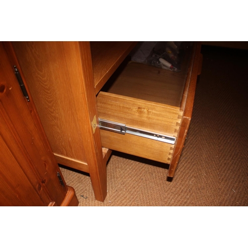 546 - A pair of Ercol light oak wardrobes enclosed panel doors with fitted interior mirror over one long d... 