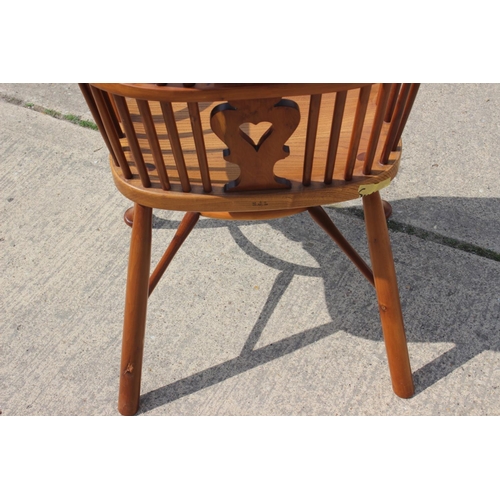 553 - A Stewart Linford yew Windsor elbow chair with pierced splat and crinoline stretcher, on turned supp... 