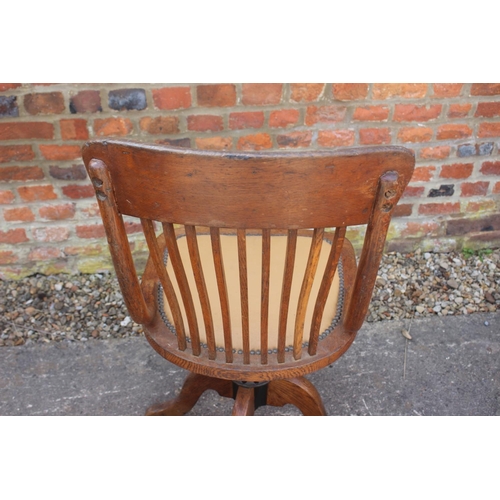 555 - A 1920s oak vertical rail back office chair, on quadruple splay support