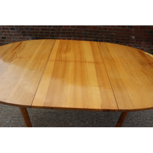 615 - A 1960s  Ercol pine oval extending dining table, on turned support, 54