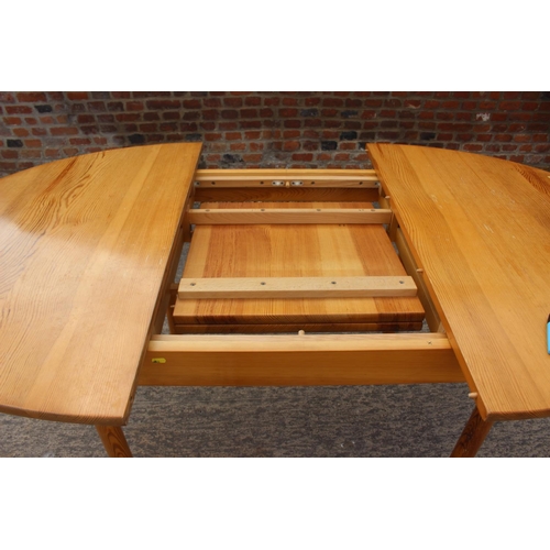 615 - A 1960s  Ercol pine oval extending dining table, on turned support, 54