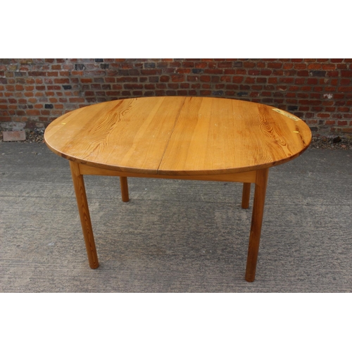 615 - A 1960s  Ercol pine oval extending dining table, on turned support, 54