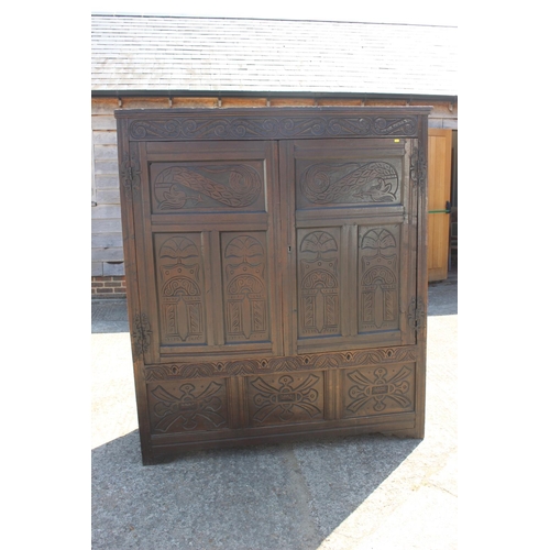 527 - An 18th century carved oak wardrobe enclosed two panelled doors with serpent hinges, on stile suppor... 