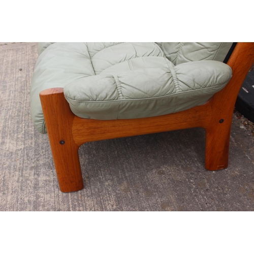 550 - A 1970s teak frame two-seat settee, upholstered in a sage green leather with loose seat and back cus... 