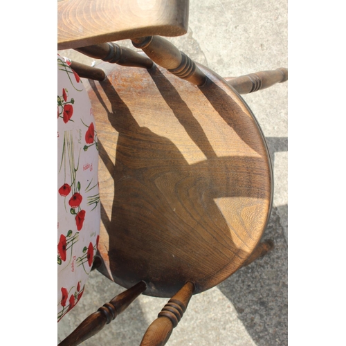 566 - An oak spindle back armchair with circular panel seat, on turned and stretchered supports