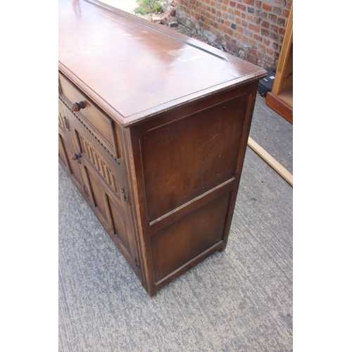 595 - An oak dresser base, fitted three drawers over arcade carved doors, on stile supports, 62