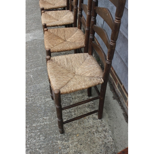 600 - A set of four polished as walnut rush seat ladderback dining chairs