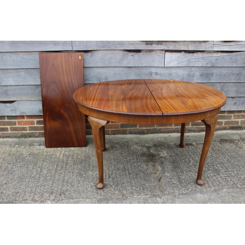 604 - An early 20th century walnut oval extending dining table with extra leaf, 70