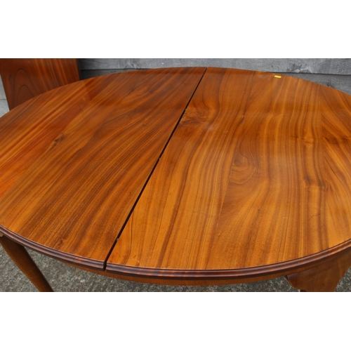 604 - An early 20th century walnut oval extending dining table with extra leaf, 70