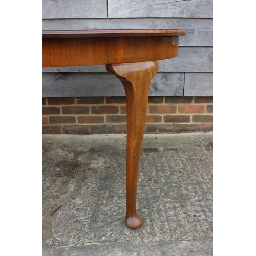 604 - An early 20th century walnut oval extending dining table with extra leaf, 70