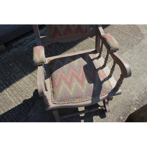 610 - An early 20th century American style grey painted rocking chair, upholstered in a zig-zag fabric