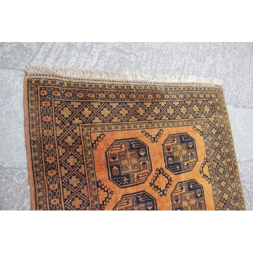 639 - A Kayam contemporary gold wash rug with eight central guls and multi-borders on an orange and natura... 