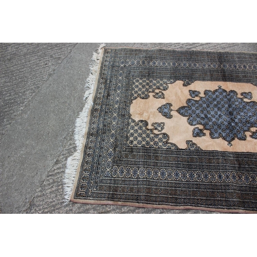 640 - A Middle Eastern rug with central medallion and multi-borders in shades of natural and grey, 59