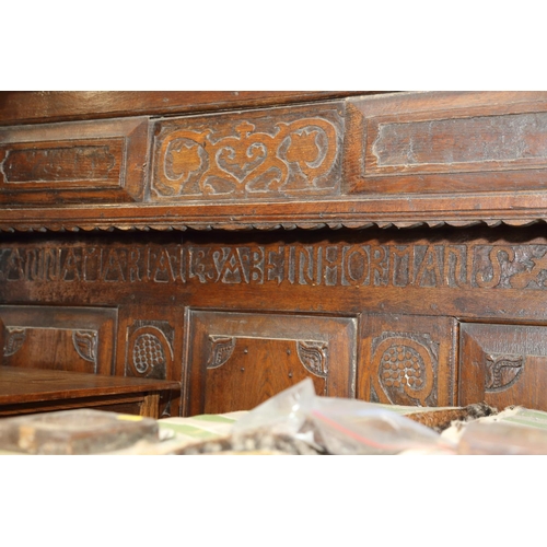 484 - A 17th century carved oak fourposter bed with panelled back, fitting sliding cupboard and inscriptio... 