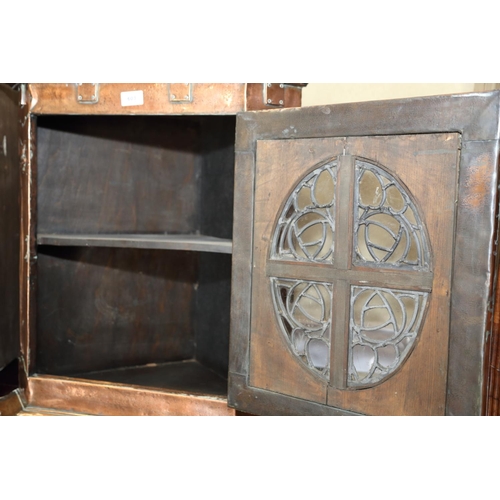 603 - An Arts & Crafts embossed copper covered corner hanging cupboard enclosed oval leaded glazed panel w... 