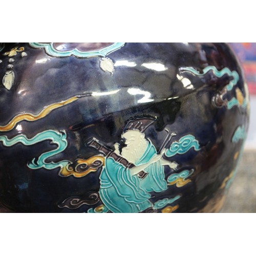 98 - A Chinese early Ming style bulbous vase with figures in clouds decoration on a dark blue ground, 11