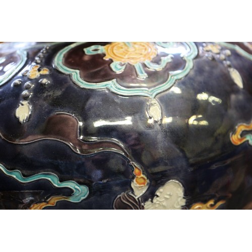 98 - A Chinese early Ming style bulbous vase with figures in clouds decoration on a dark blue ground, 11