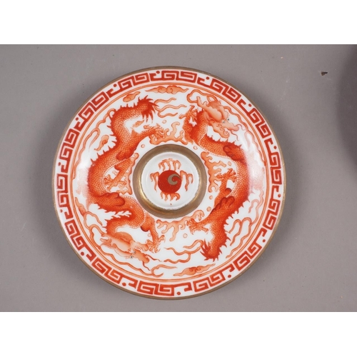 78 - A pair of Chinese iron red and white glazed tea bowls and saucers, decorated dragons and flaming pea... 