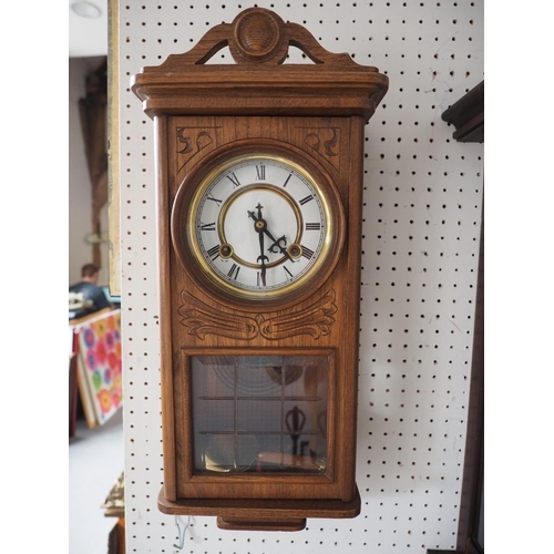 118 - A 1930s carved oak cased wall clock with eight-day striking movement, 21