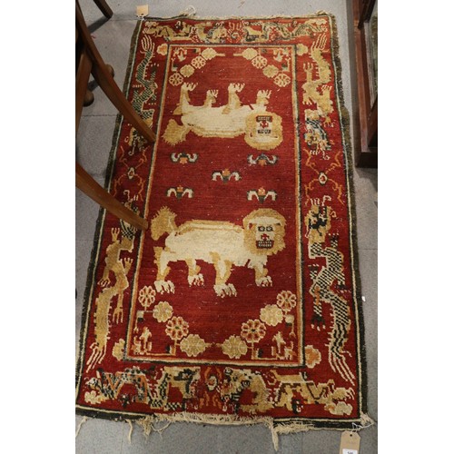 546 - A Tibetan? rug with lion design on a red ground, 59