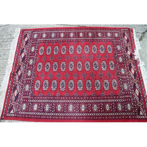 544 - A Bokhara rug of traditional design with thirty guls on a red ground, 66