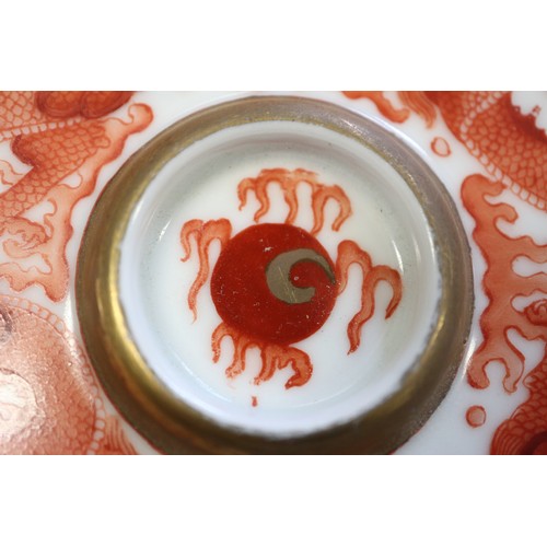 78 - A pair of Chinese iron red and white glazed tea bowls and saucers, decorated dragons and flaming pea... 